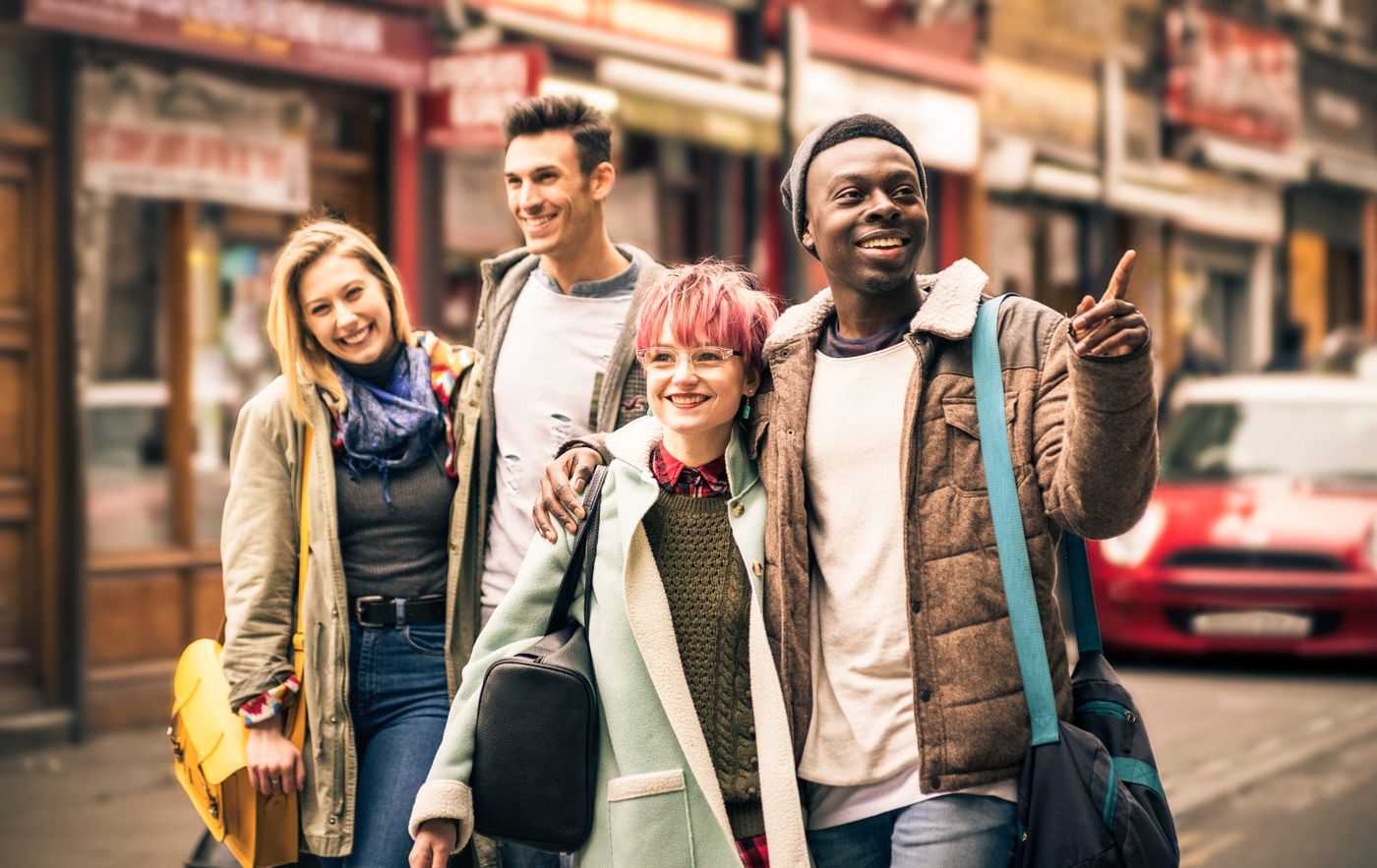 Group of young adult friends walking together in the street