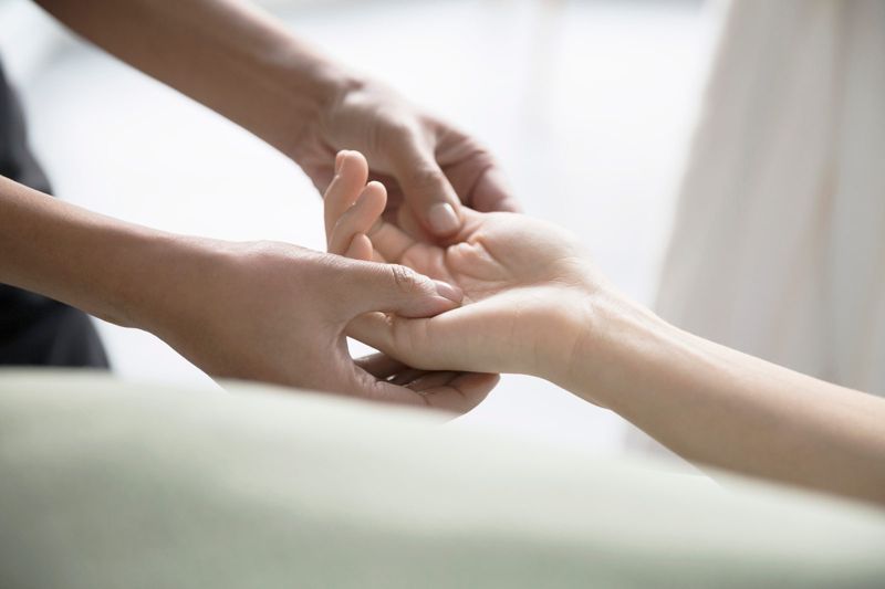 Carer holding a person's hands