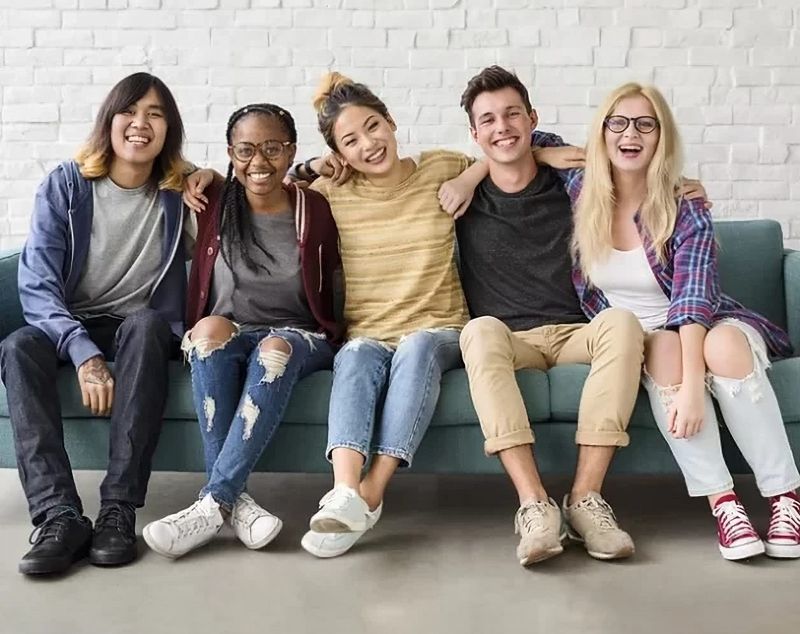 Group of young people sitting together on a sofa