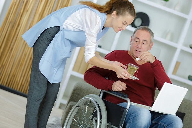 Carer chatting with a man in a wheelchair