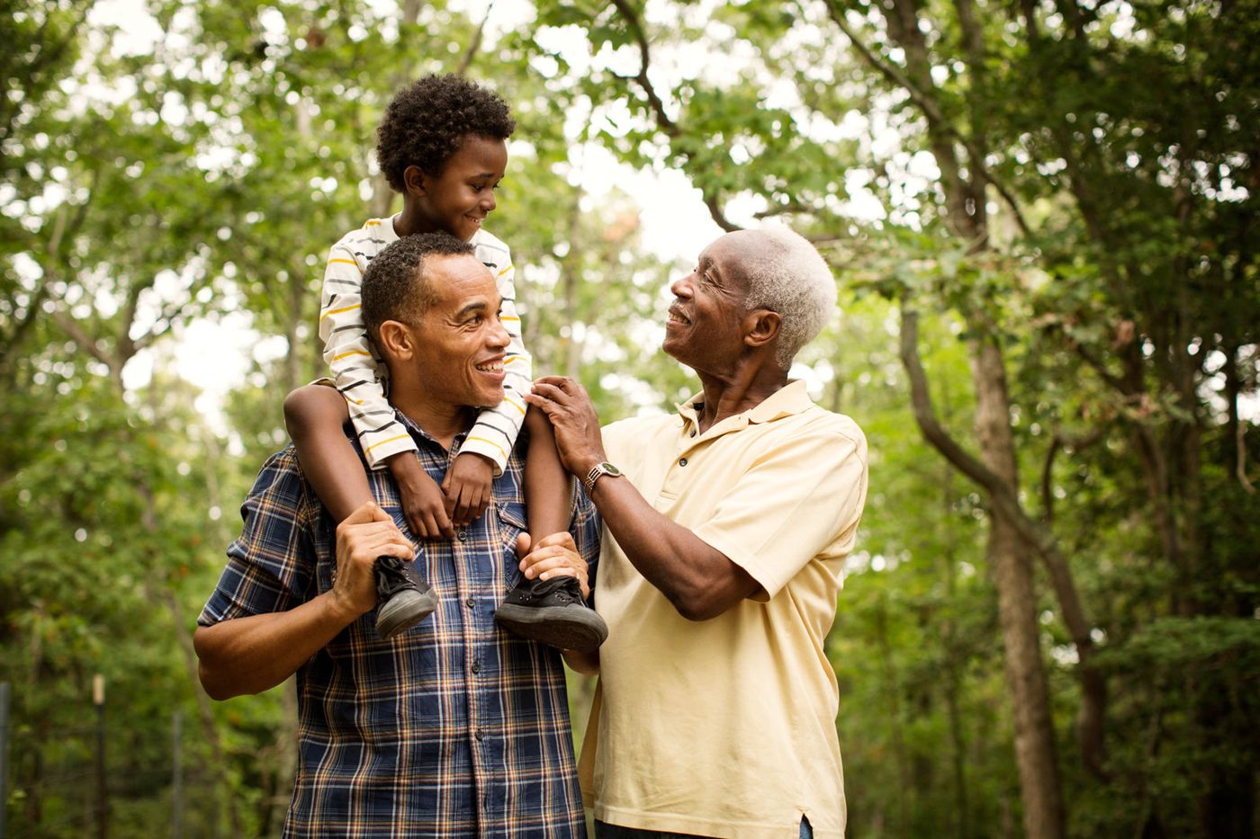 Three generations of a family smiling together outdoors